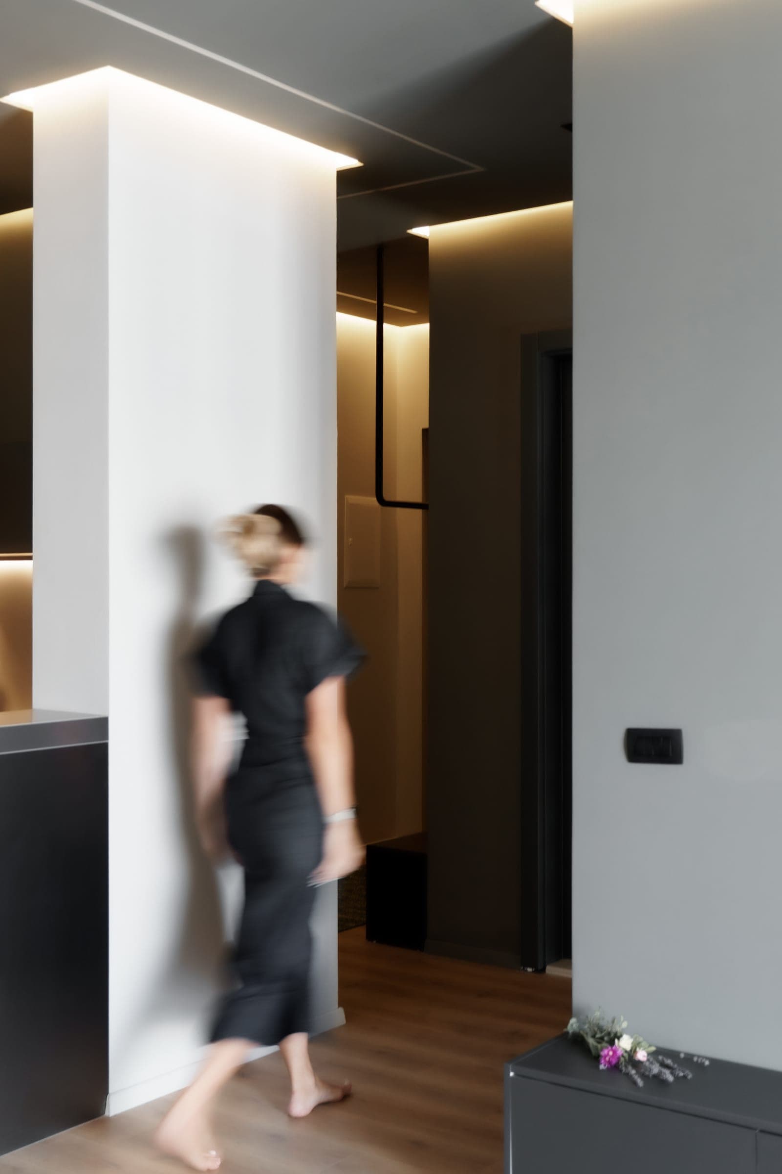 Hallway with concealed ceiling lighting around a white column