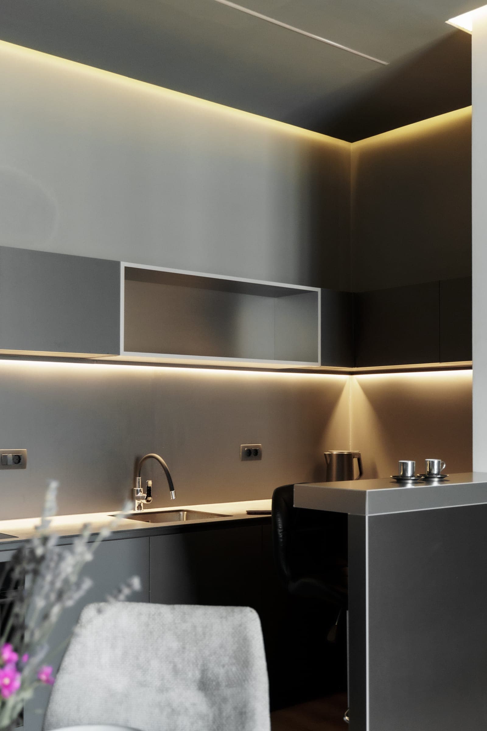 Kitchen with dark cabinetry and concealed lighting